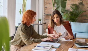 Two woman looking over a document